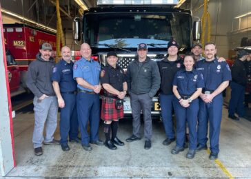 Firefighters standing in front of a fire engine