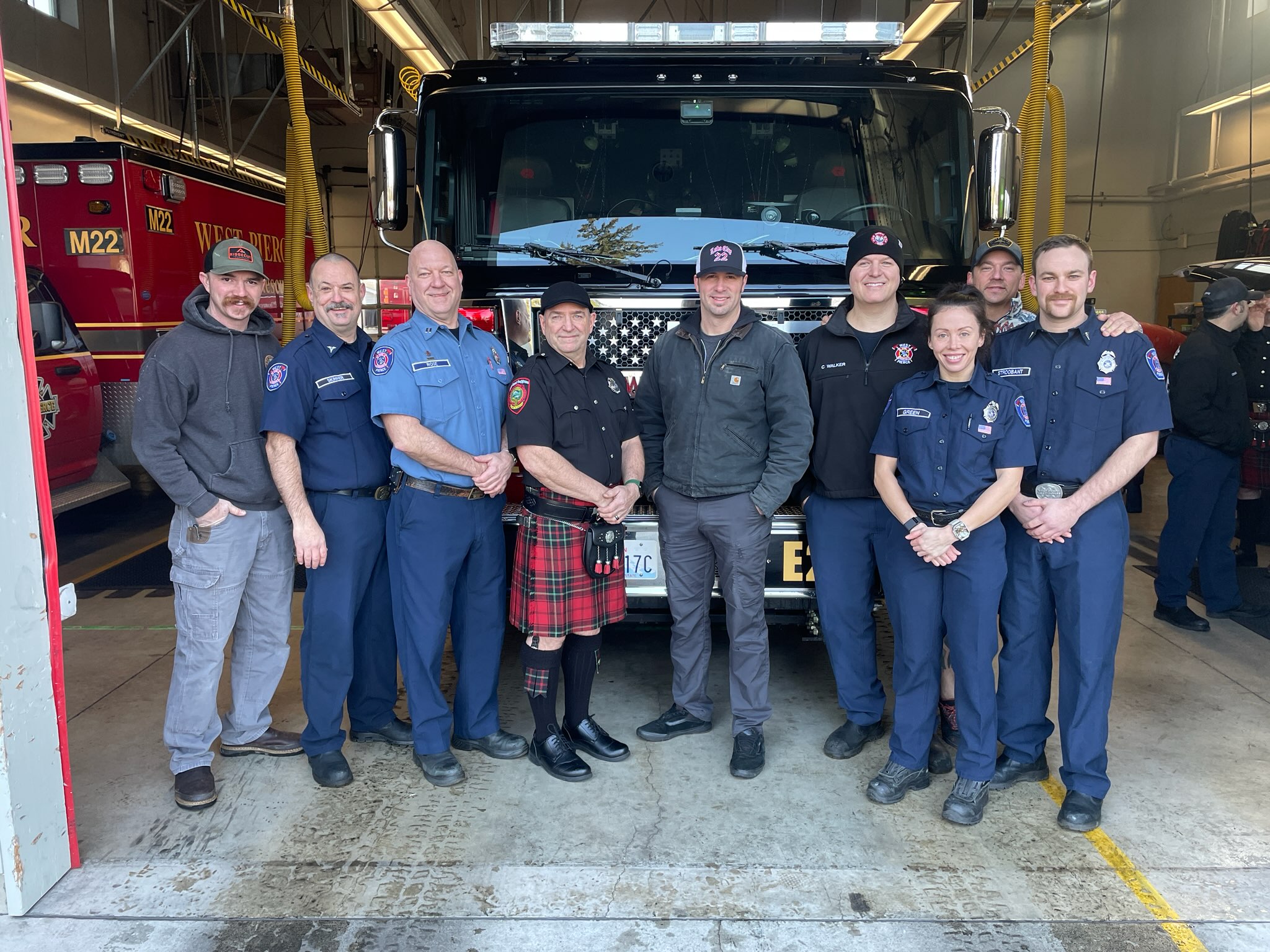 Firefighters standing in front of a fire engine